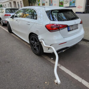 Weißer Mercedes A-Klasse mit beschädigter Heckstoßstange am Straßenrand in Berlin